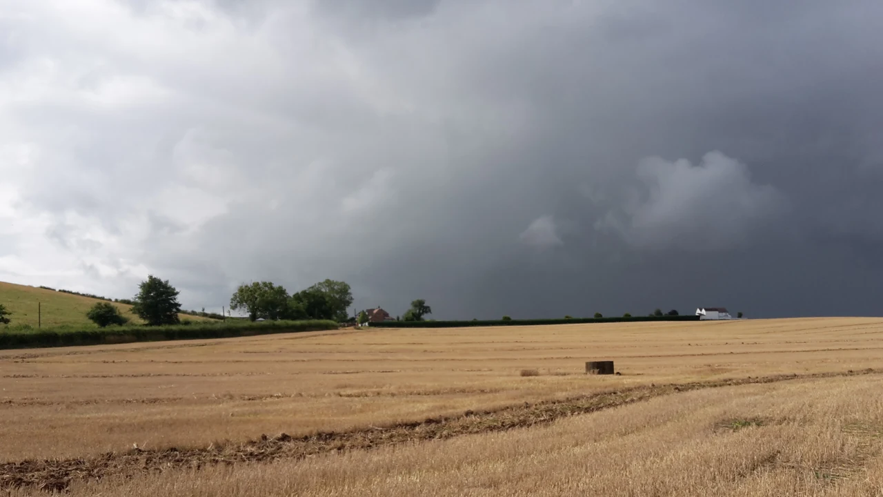 Harvested cereal field under storm clouds; illustrative historical photograph, UK, 2018 — September crop monitoring separates summer losses from autumn seed risks